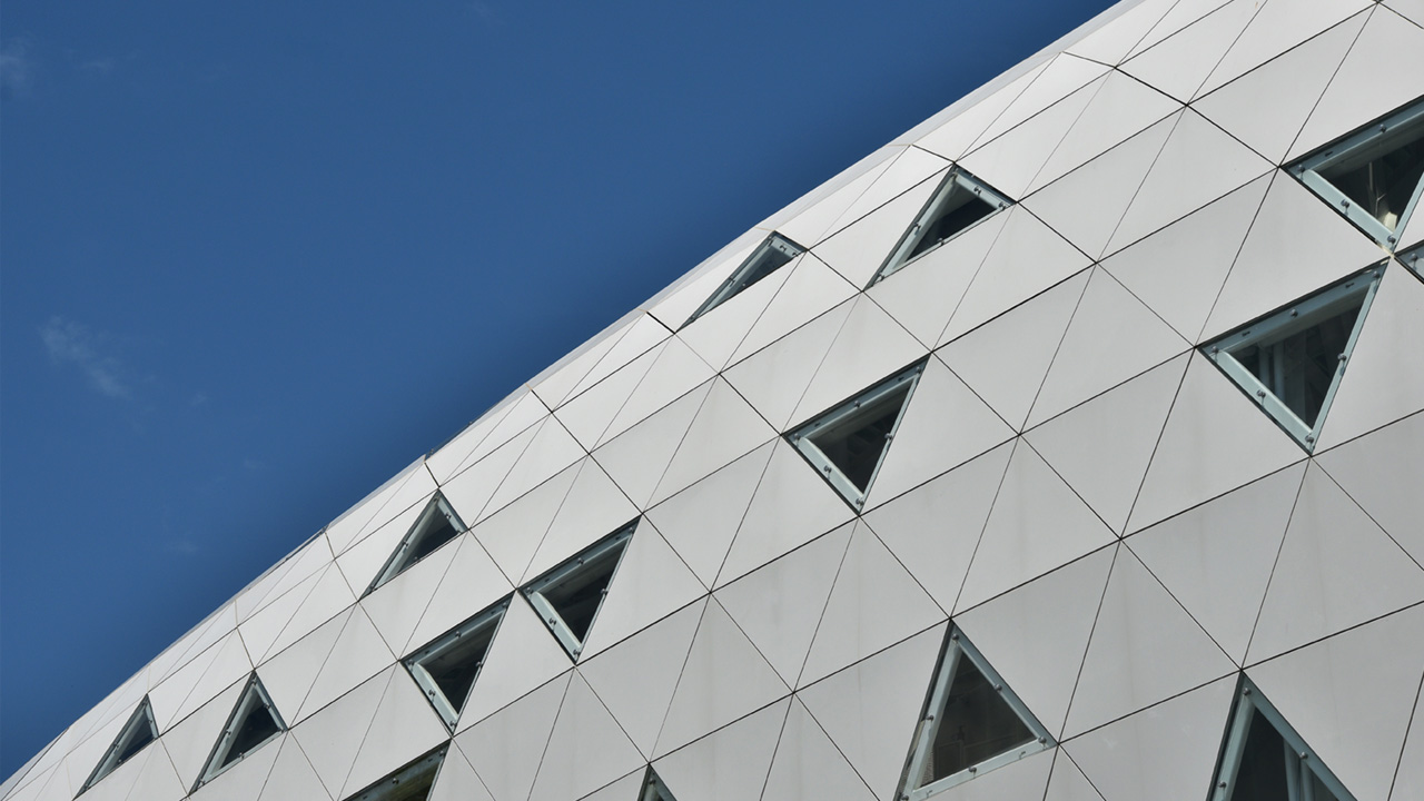 Moderna siva fasada popločena trokutima s trokutastim prozorima
