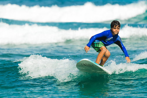 Fotografija prikazuje dječaka koji surfa.