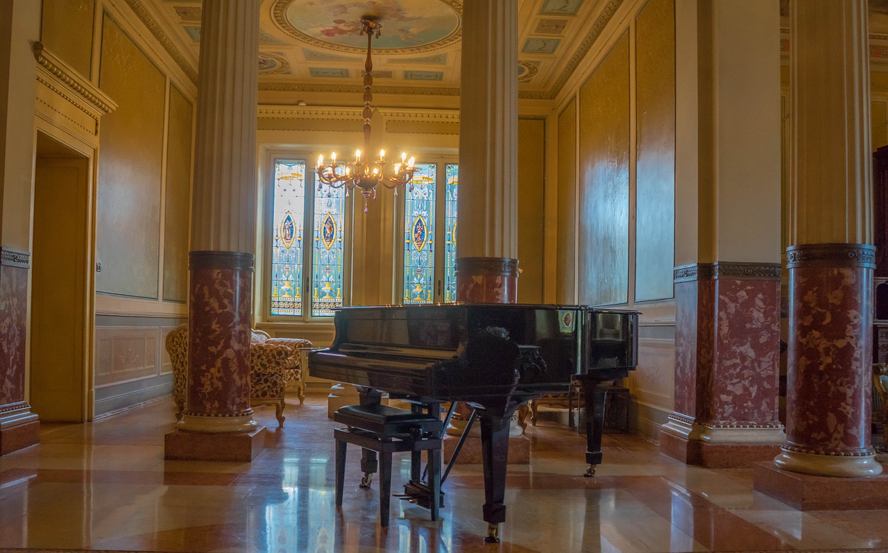 Slikom je prikazan prostrani hodnik u središtu kojeg se nalazi klavir.