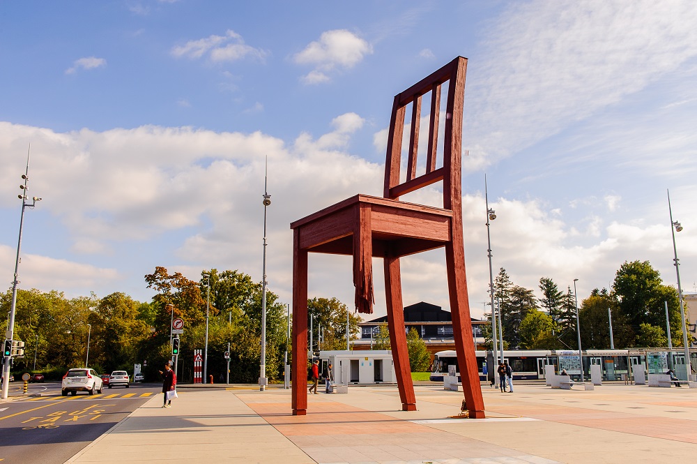 Slika prikazuje drvenu skulpturu „Slomljeni stolac“ u Ženevi.