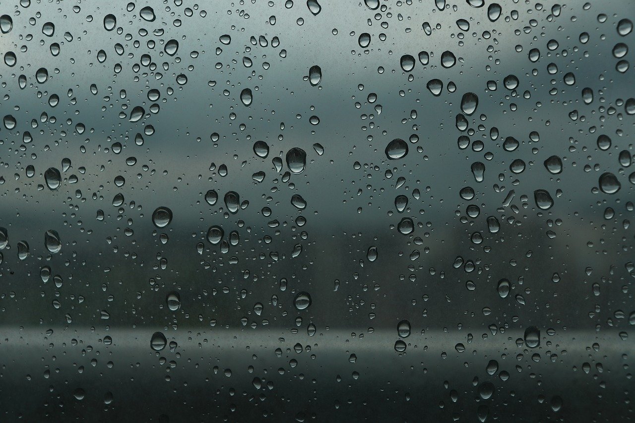 Slikom je prikazan prozor s kapljicama kiše.