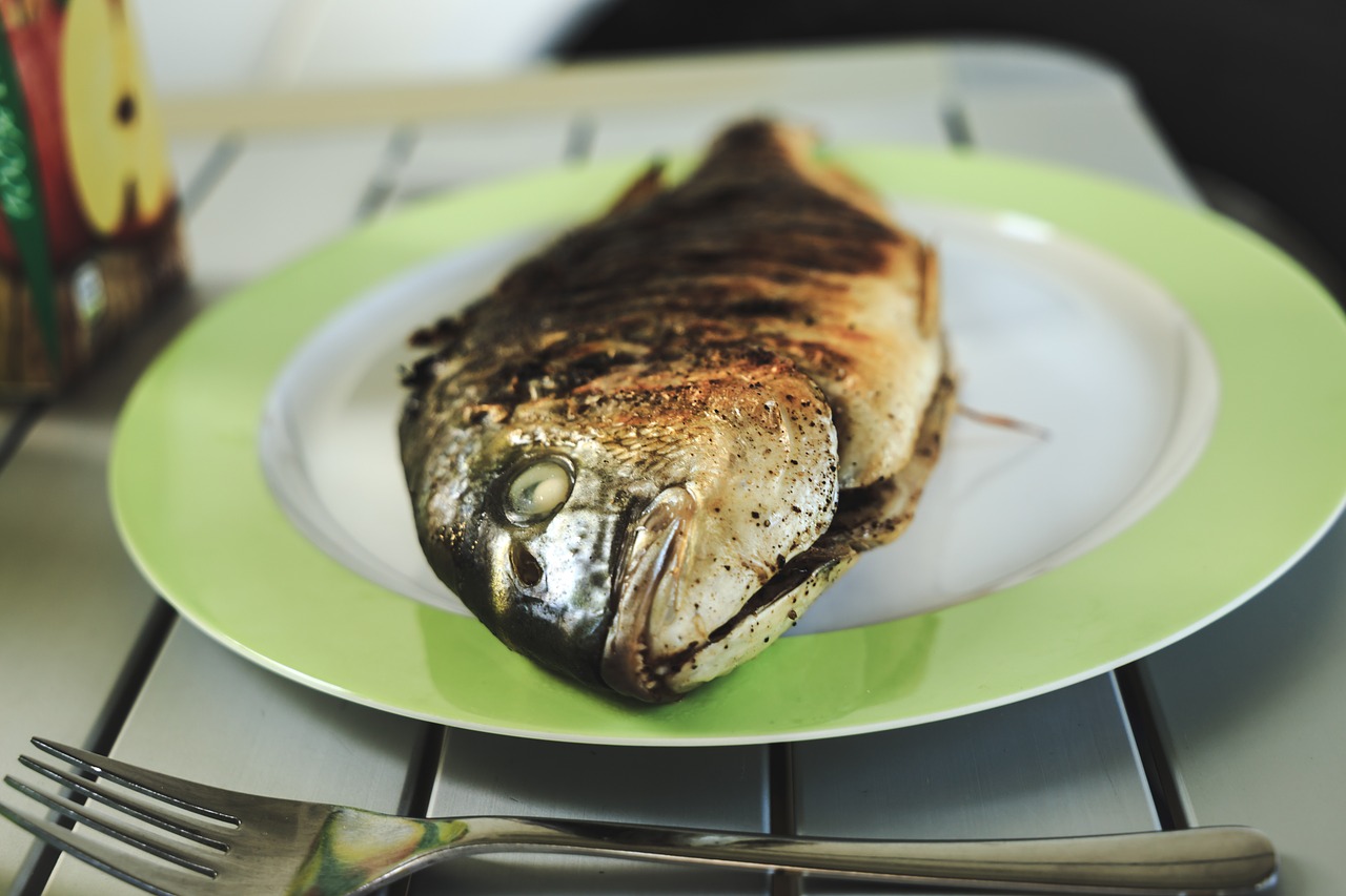Na slici je prikazana pečena riba u tanjuru.