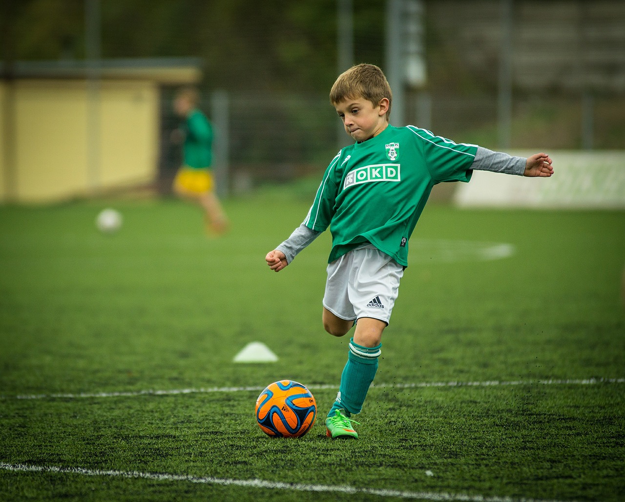Slikom se prikazuje dječak koji igra nogomet.