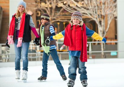 Slikom se prikazuju djeca i odrasli koji kližu na ledu.