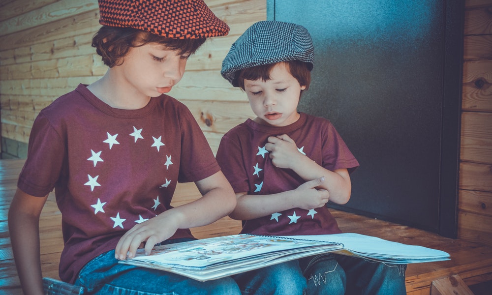 Slikom su prikazana dva dječaka koja čitaju.
