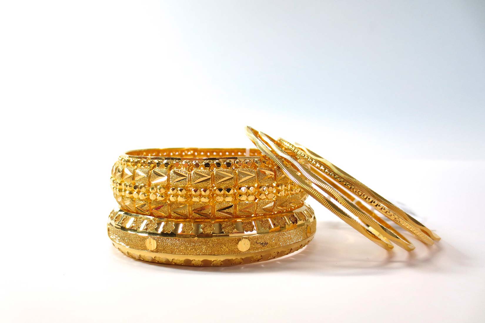 Na slici je prikazan zlatni nakit. Dvije debele zlatne narukvice reljefnog uzorka i tri tanke narukvice.