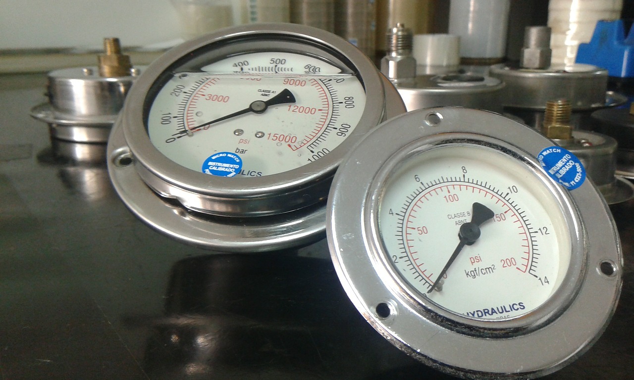 Na slici je prikazan manometar – mjerni uređaj za mjerenje tlaka plina ili tlaka tekućina. U obliku je okruglog sata (prikazana su dva sata) s jednom kazaljkom koja pokazuje vrijednost tlaka.Okvir je sive boje.