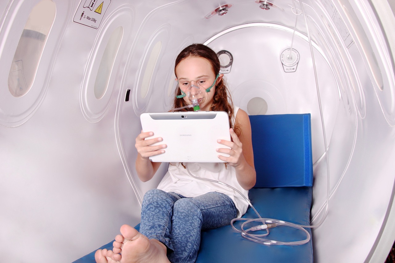 Prikazan je slika barokomore – uređaja koji je namijenjen liječenju pacijenta koji je izložen udisanju 100 -postotnog kisika u uvjetima povišenog tlaka. Na slici je prikazana djevojka koja sjedi u komori i gleda nešto na računalu kojeg drži u rukama ispred sebe. U nosu su joj cjevčice koje dovode kisik.Komora izgleda kao zatvorena bijela prostorija (kapsula).