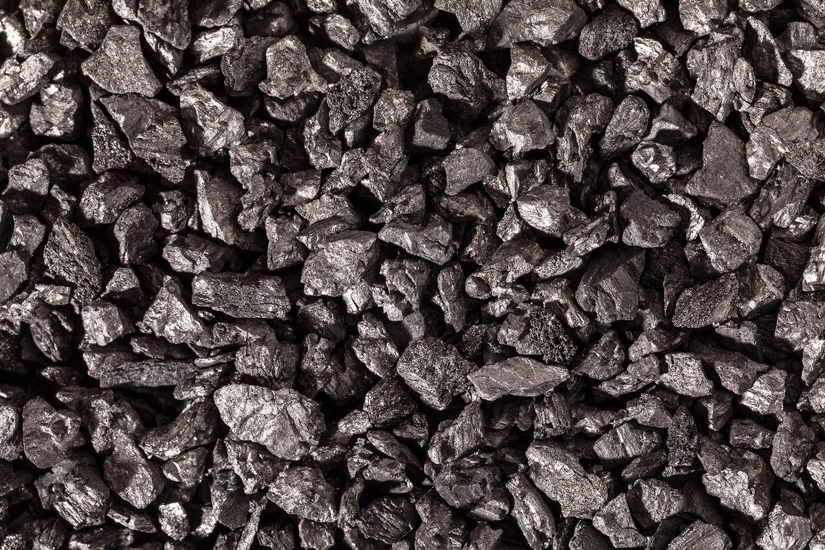 Fotografija prikazuje komadiće aktivnog ugljena sive boje i nepravilna oblika.