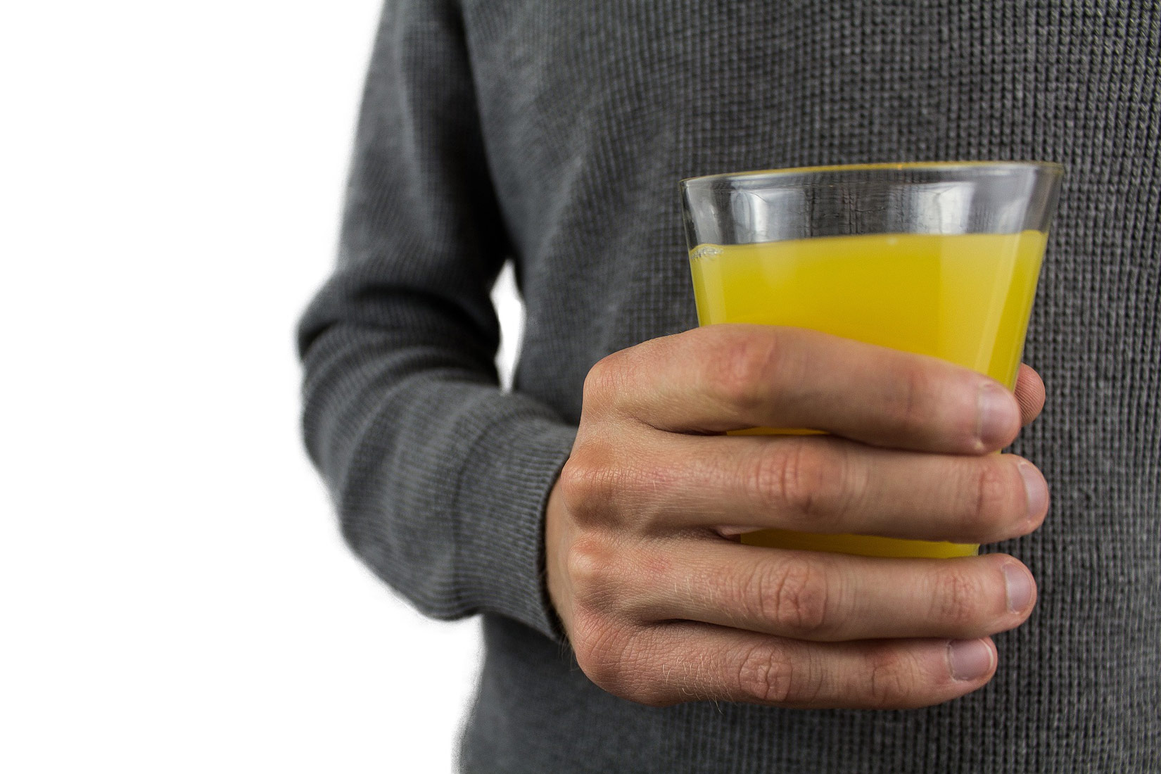 Fotografija prikazuje čašu žutog voćnog soka.