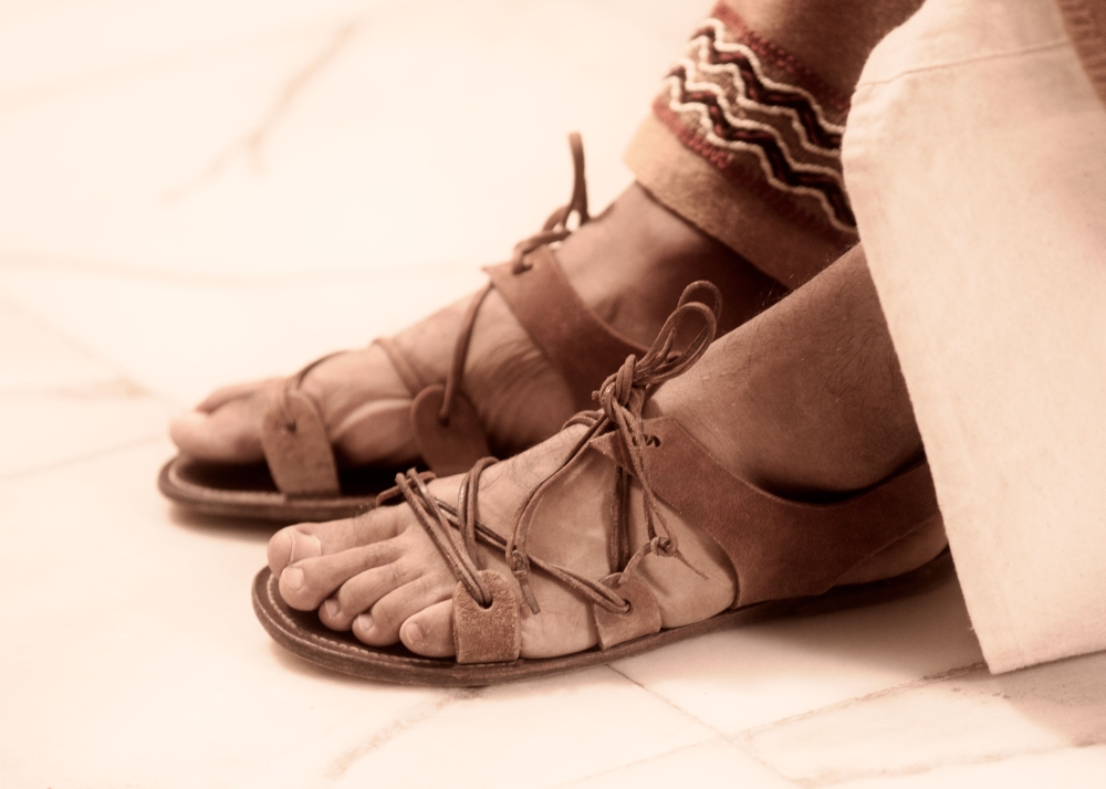Na ovoj su slici prikazane rimske sandale na muškim nogama.