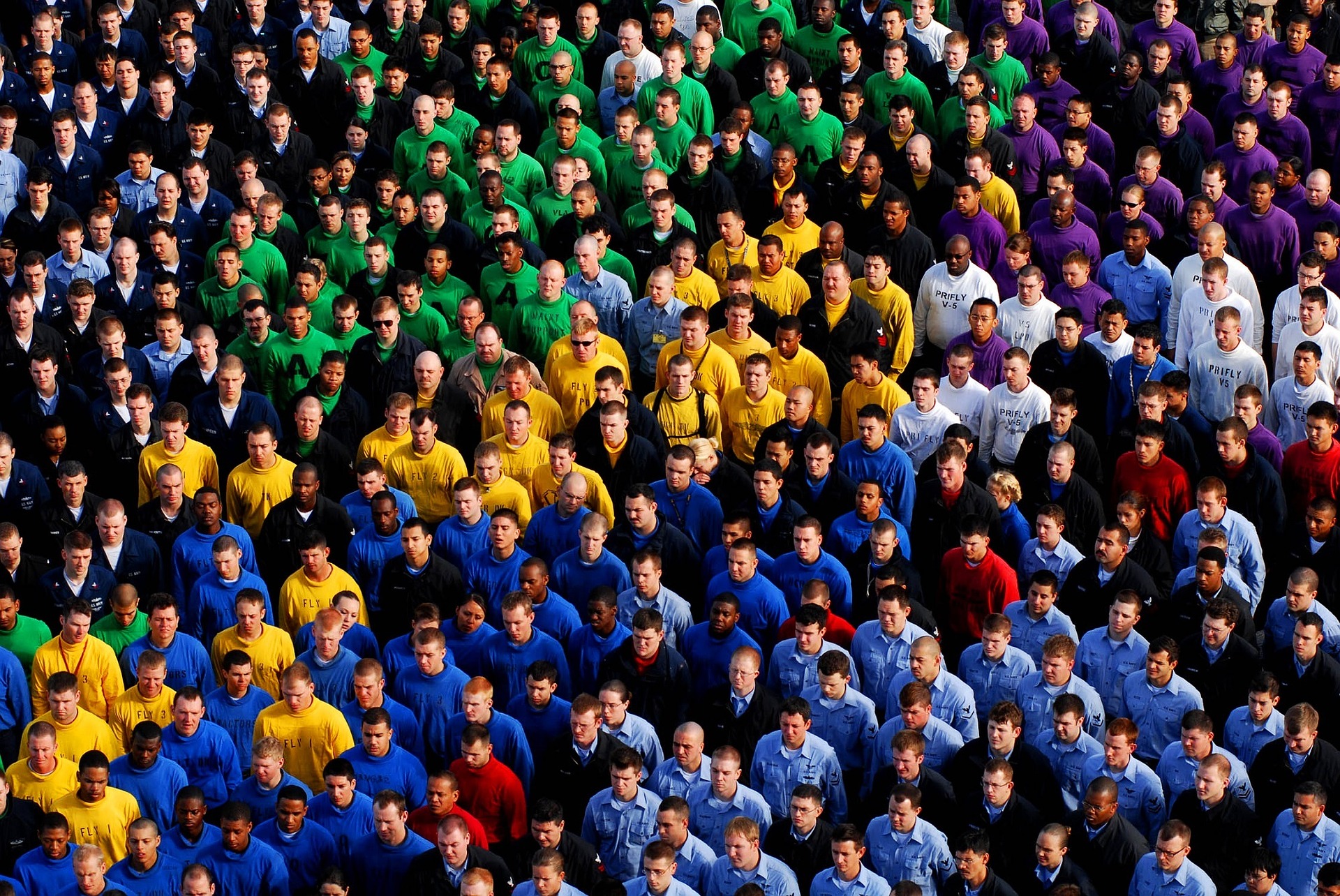 Slika prikazuje mnoštvo ljudi grupiranih po bojama majici.
