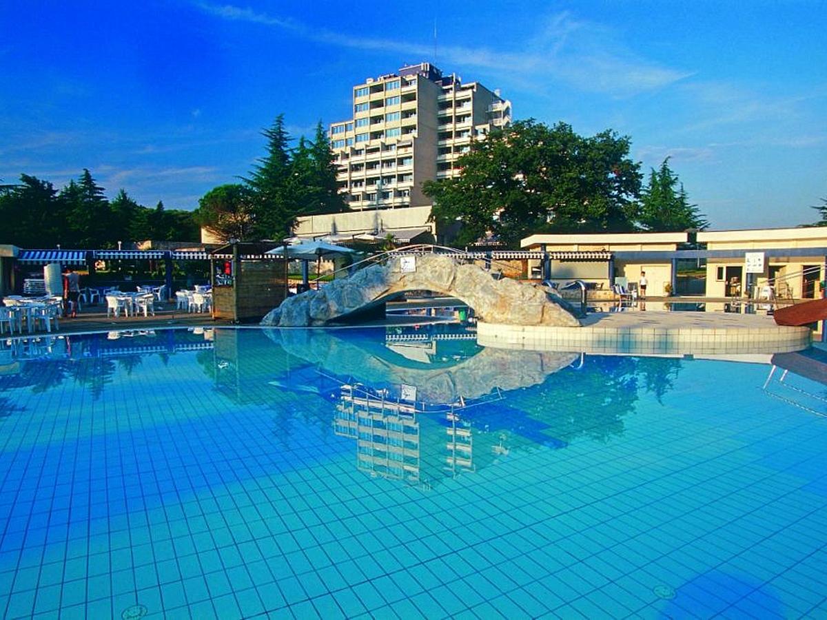 Na fotografiji je prikazan hotel s vanjskim bazenom.