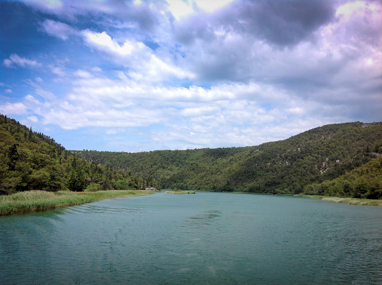 Rijeka Krka okružena planinama bogate vegetacije.