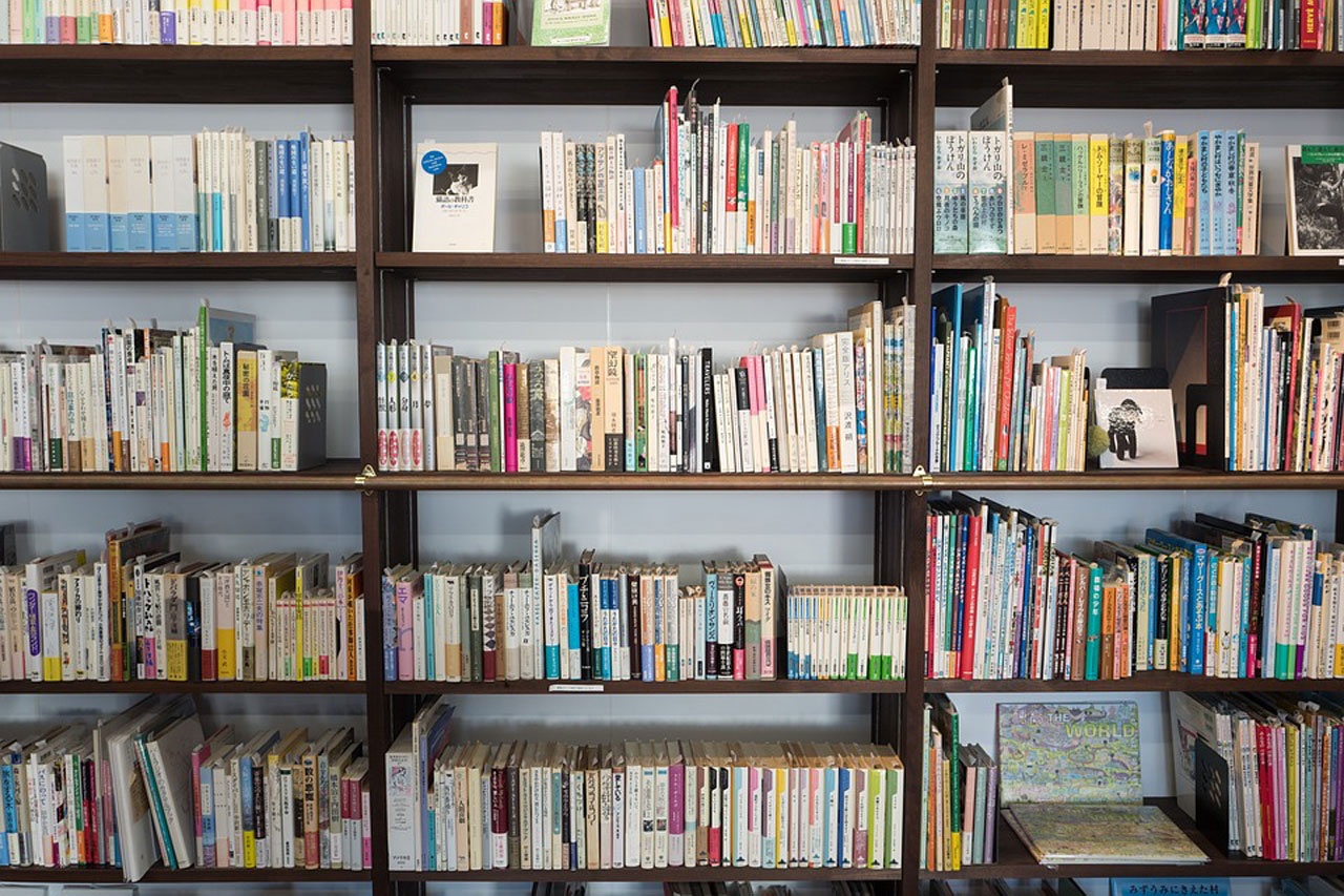 Fotografija prikazujeotvoreni ormar podijeljen na police za knjige.