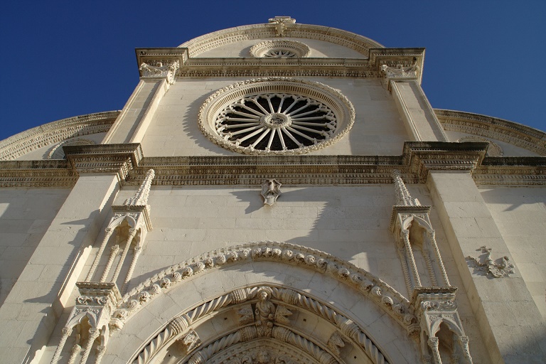 Slika prikazuje osnosimetričnu građevinu - pročelje Katedrale u Šibeniku.