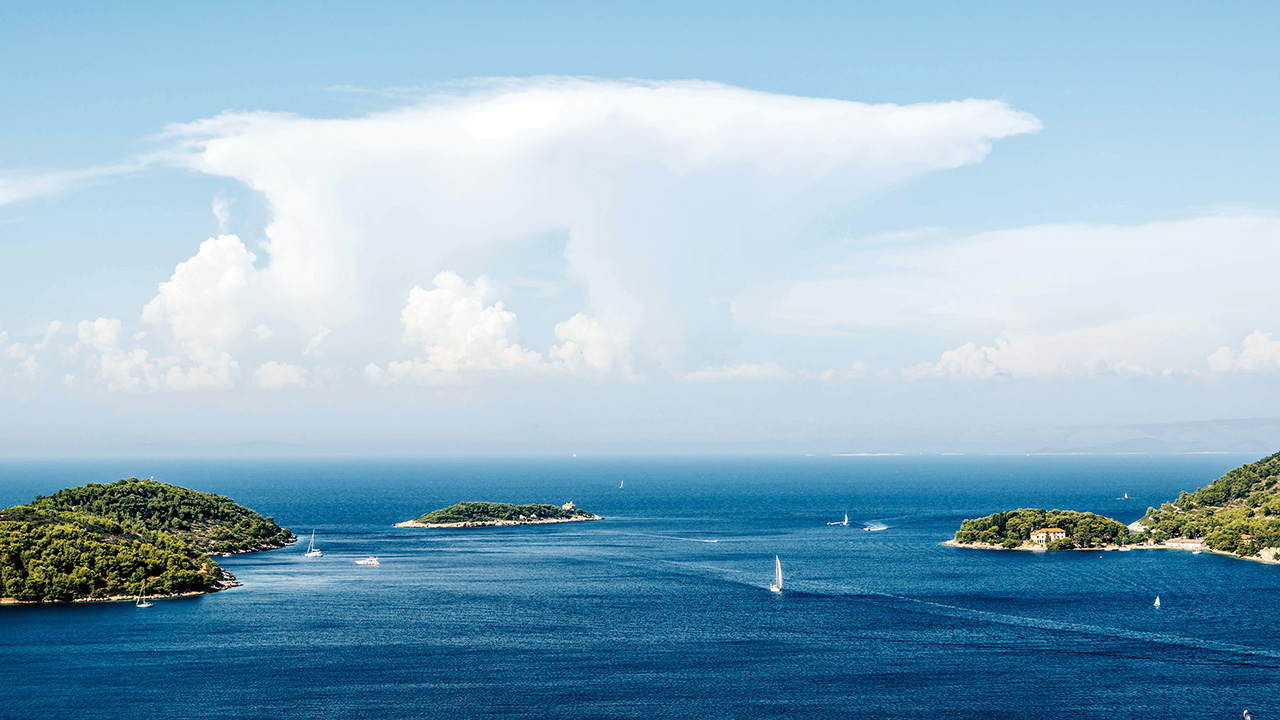 Panorama otoka Visa s brojnim jedrilicama i gliserima.