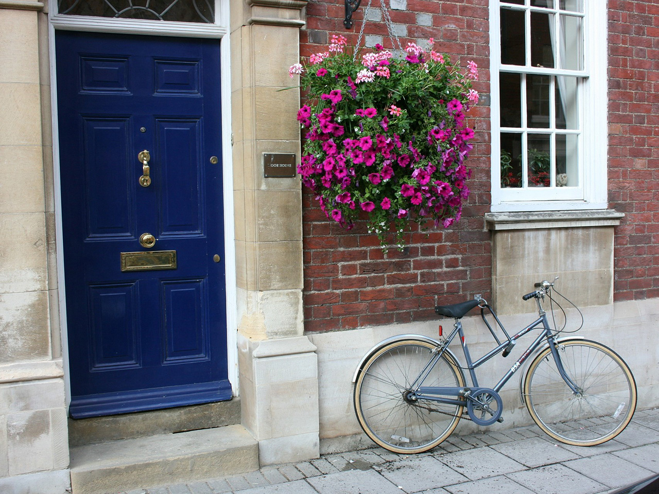 Bicikl na ulici pored ulaznih vrata kuće. 