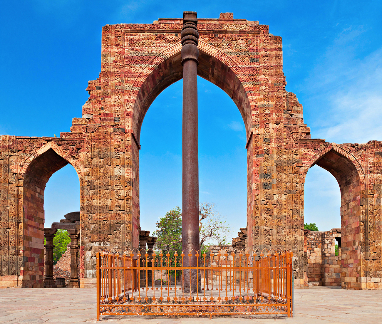 Fotografija prikazuje visoki stup od željeza, nalazi se ispred jednog kamenog ulaza.
